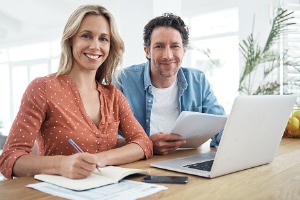 Couple smiling at camera with paperwork